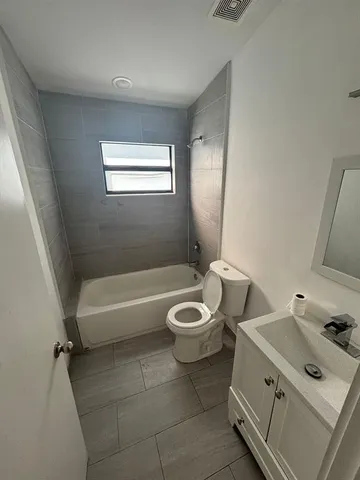 a bathroom with a toilet sink vanity tub and shower