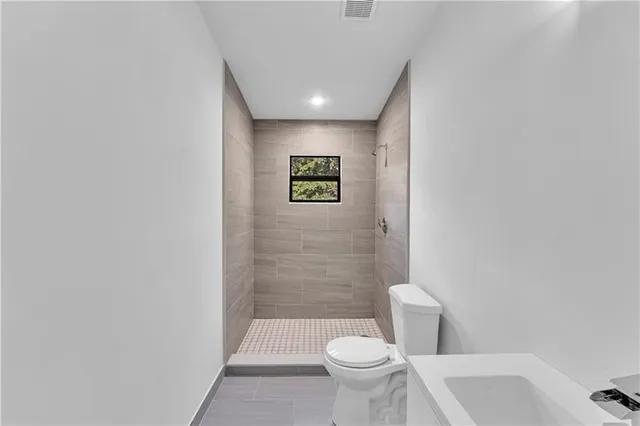 a bathroom with a toilet sink and shower