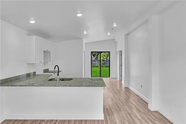 a kitchen with kitchen island granite countertop a sink and a granite counter tops