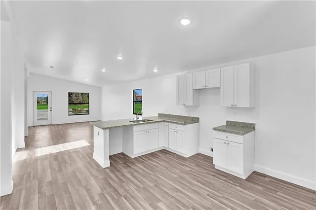 a kitchen with granite countertop a stove top oven and cabinets