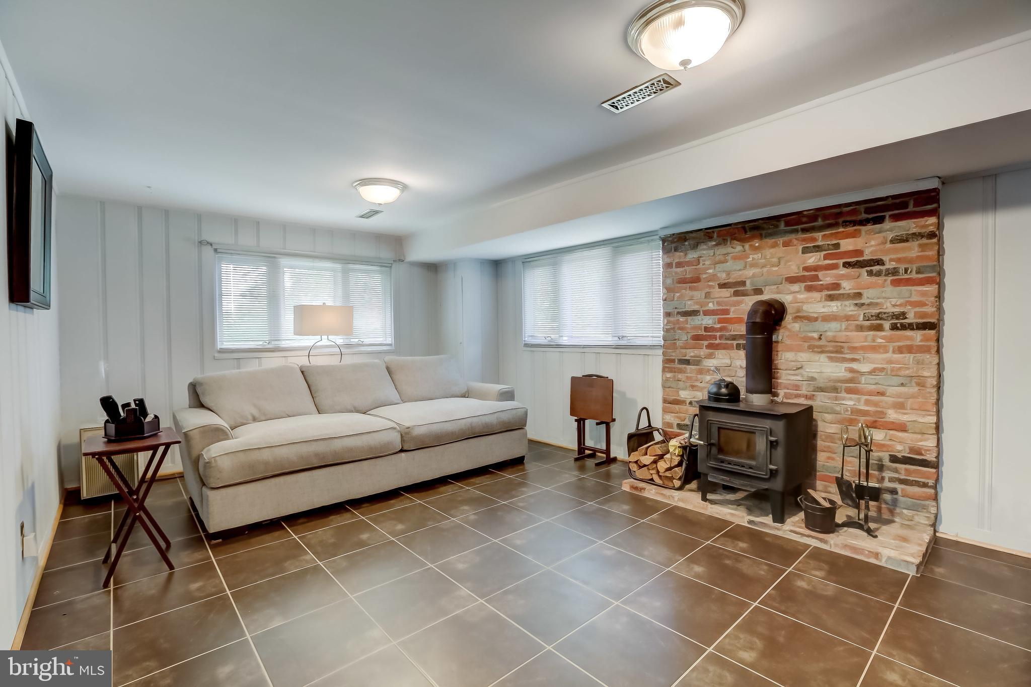 506 Upland Road Baltimore, MD 21208 - Photo 12 of 35 Living area w/ wood burning stove and ceramic tile