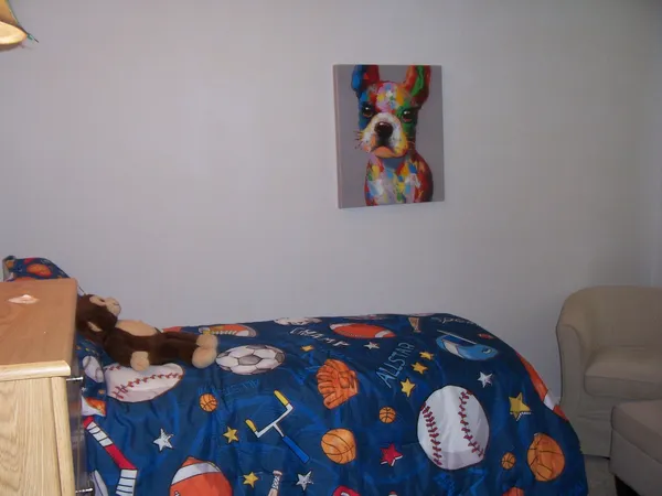 a bedroom with a bed and a lamp on the dresser