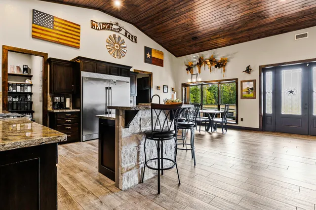 a kitchen with stainless steel appliances granite countertop a kitchen island a stove a sink and a microwave