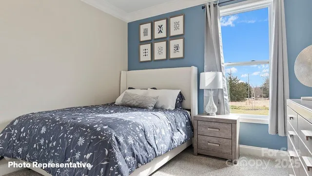 a bed sitting in a bedroom next to a window