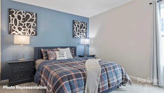 a bedroom with a bed and a lamp on dresser