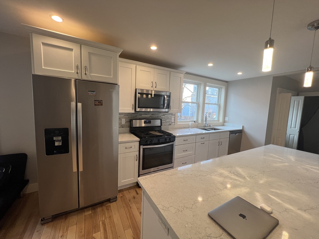 39 Snow Street, Unit 1 Boston, MA 02135 - Photo 1 of 35 a kitchen with a refrigerator and a stove top oven