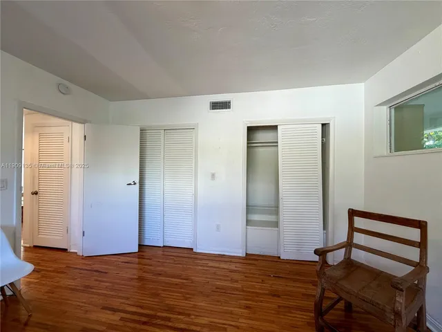 a view of a livingroom with wooden floor and staircase