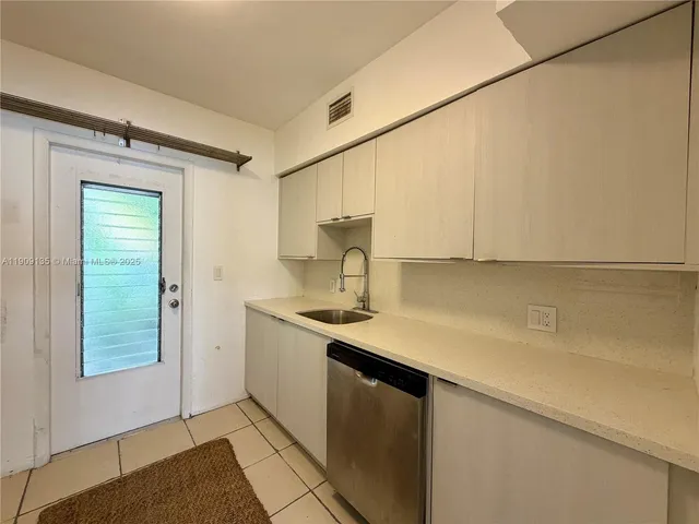 a kitchen with a sink cabinets and a window