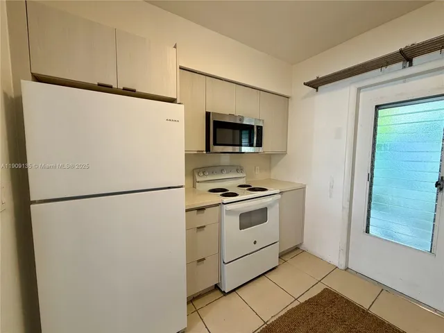 a white refrigerator freezer and a stove sitting inside of a kitchen