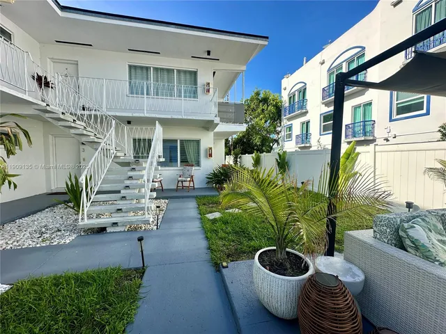 a view of a patio with plants and chairs potted plants