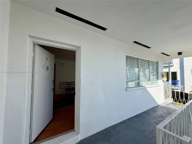 a view of a hallway with wooden floor and a living room