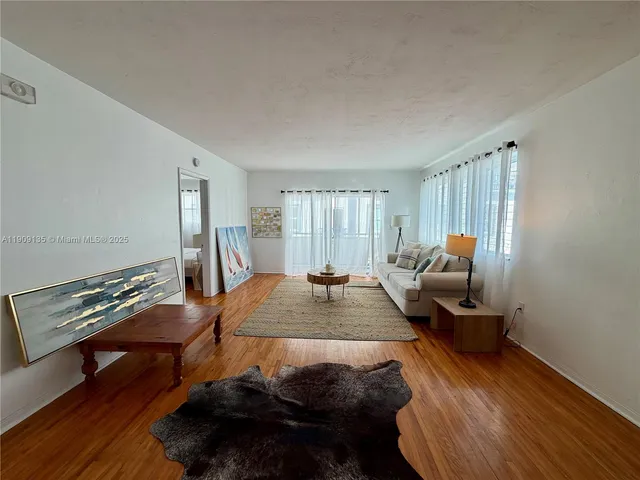 a living room with furniture a rug and a window