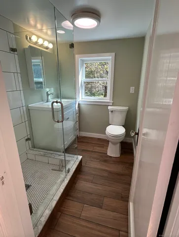 a bathroom with a sink a toilet a mirror and window