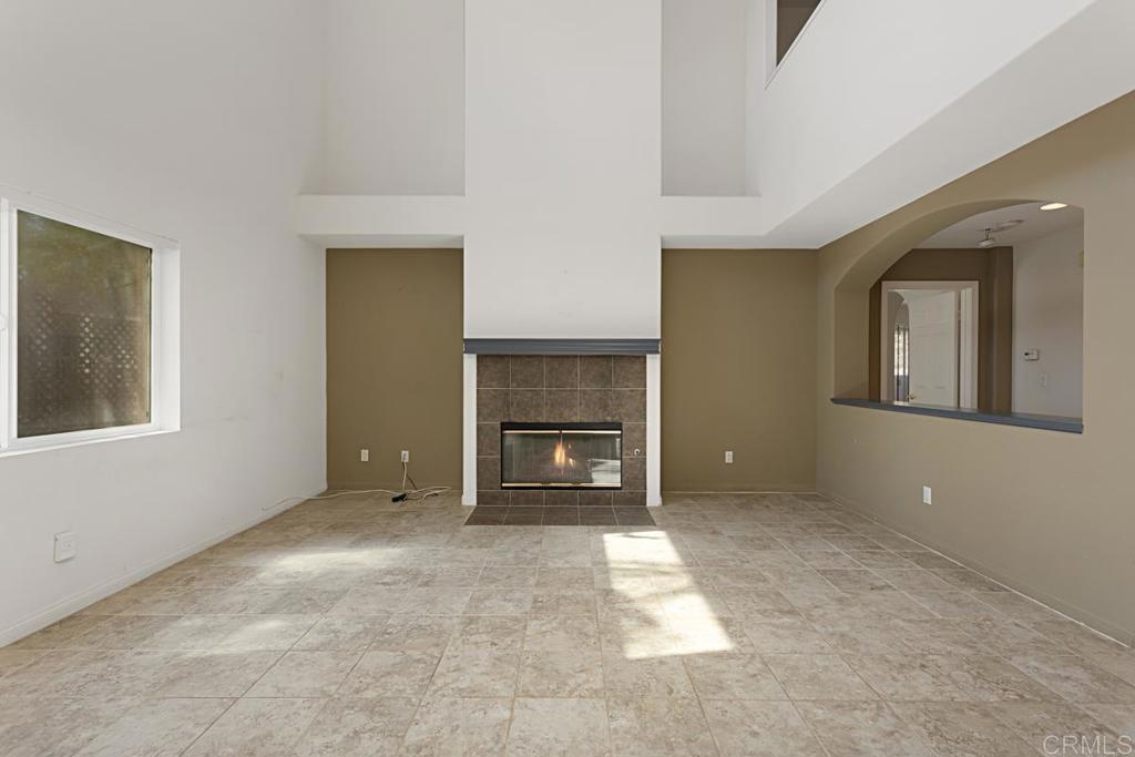 1691 Hubbard Place Escondido, CA 92027 - Photo 13 of 39 a view of an empty room with a fireplace and a window