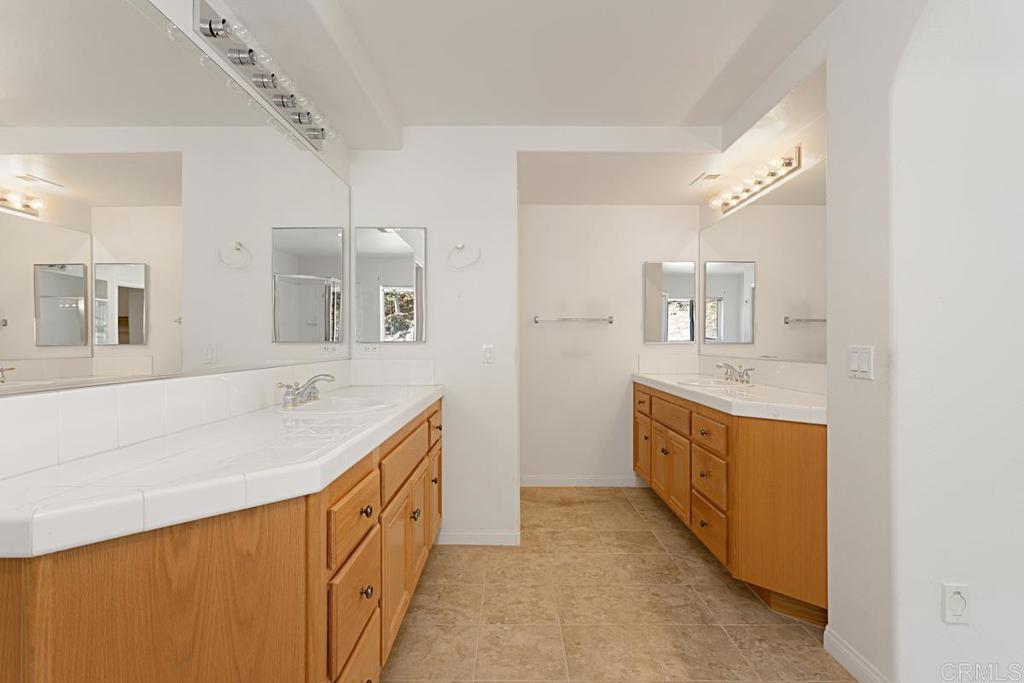 1691 Hubbard Place Escondido, CA 92027 - Photo 23 of 39 a spacious bathroom with a double vanity sink a mirror and a bathtub