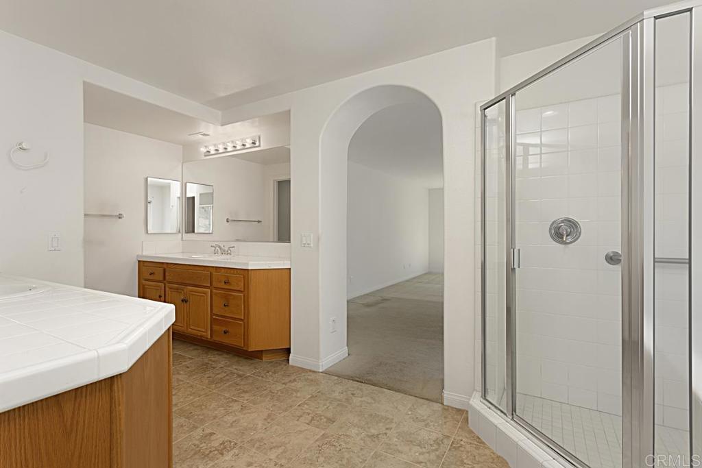 1691 Hubbard Place Escondido, CA 92027 - Photo 24 of 39 a bathroom with a granite countertop sink mirror and a bathtub