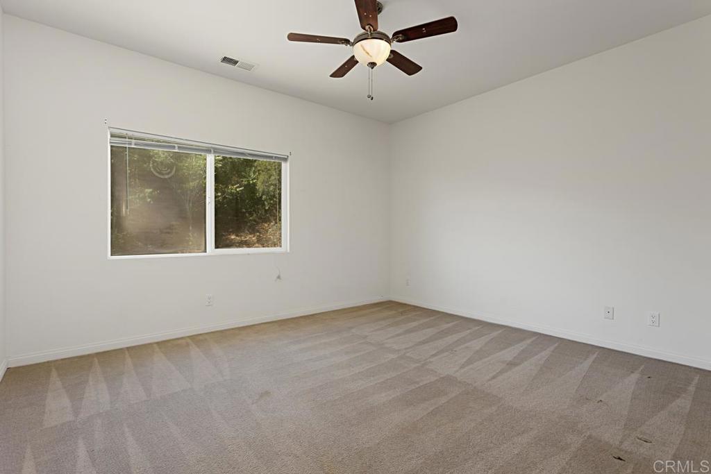 1691 Hubbard Place Escondido, CA 92027 - Photo 32 of 39 an empty room with a window and a ceiling fan