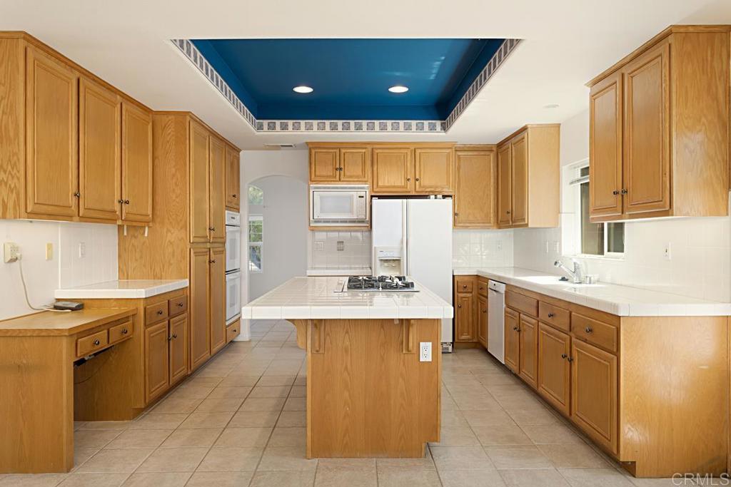 1691 Hubbard Place Escondido, CA 92027 - Photo 8 of 39 a open kitchen with stainless steel appliances granite countertop a stove and a refrigerator