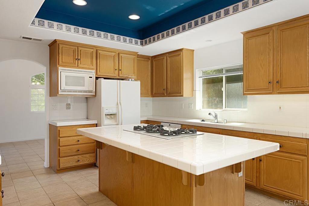 1691 Hubbard Place Escondido, CA 92027 - Photo 9 of 39 a kitchen with stainless steel appliances a stove a sink and a refrigerator