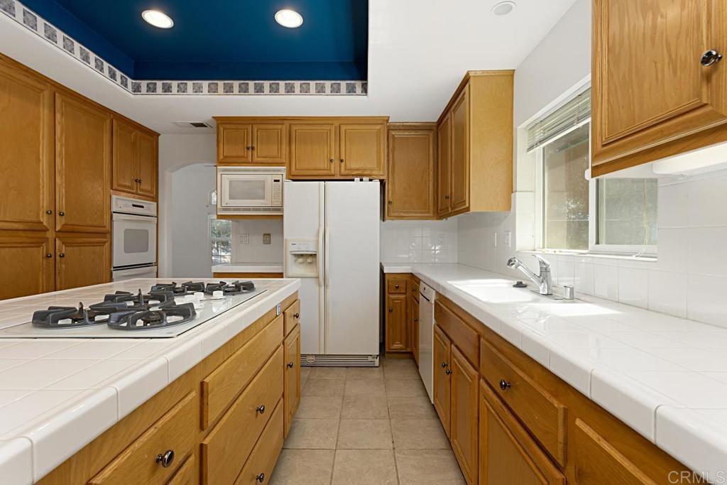 1691 Hubbard Place Escondido, CA 92027 - Photo 10 of 39 a kitchen with a sink stove and refrigerator