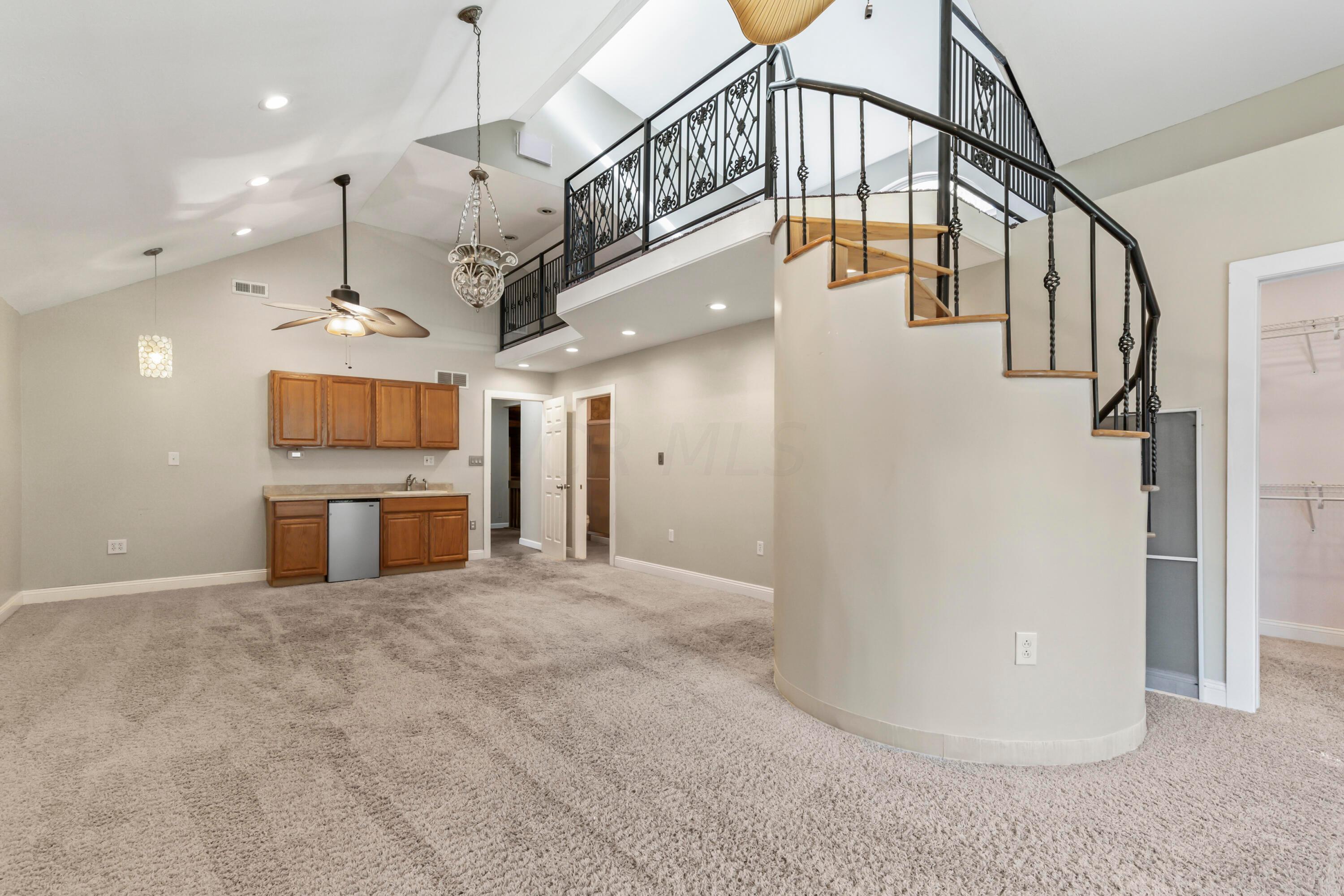 9495 Kilbourne Road Sunbury, OH 43074 - Photo 52 of 84 • Light sand carpet
• Tan painted walls
• (2) lighted ceiling fans
• Window seat
• Vaulted ceiling
• Can lighting
• Hanging lights
• Wet bar with mini refrigerator
& cabinets
• Spiral staircase to Loft