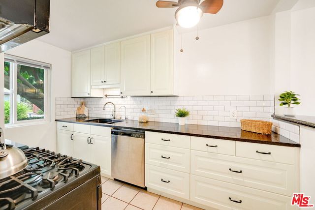 a kitchen with granite countertop white cabinets and white appliances
