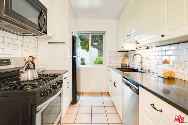 a kitchen with stainless steel appliances granite countertop a stove and a sink