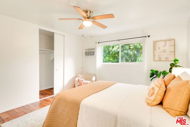a bedroom with a bed and a large window