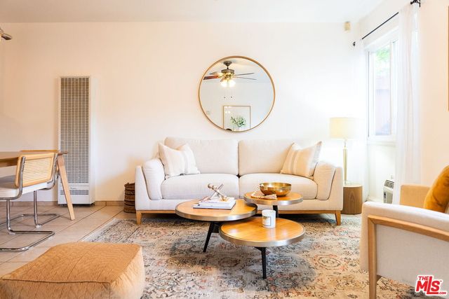 a living room with furniture a rug a lamp and a window