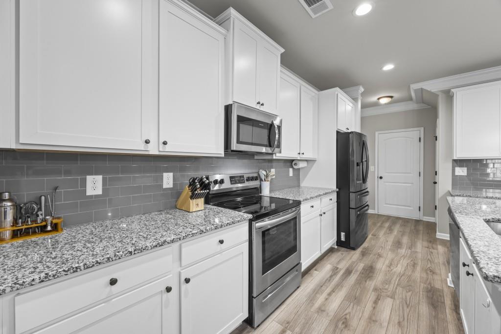 660 Country Ridge Drive Hoschton, GA 30548 - Photo 20 of 58 a kitchen with granite countertop stainless steel appliances a sink cabinets and a counter top space