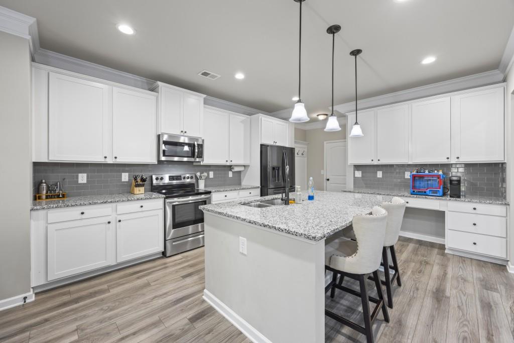 660 Country Ridge Drive Hoschton, GA 30548 - Photo 21 of 58 a kitchen with white cabinets stainless steel appliances and kitchen island