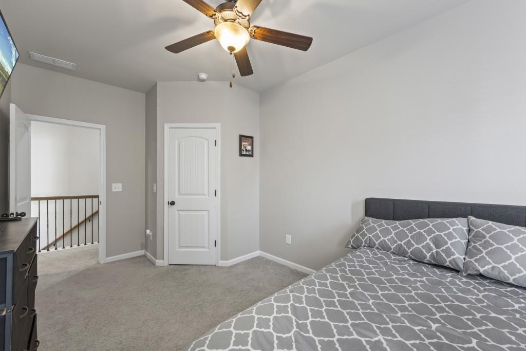 660 Country Ridge Drive Hoschton, GA 30548 - Photo 27 of 58 a bedroom with a bed and a chandelier