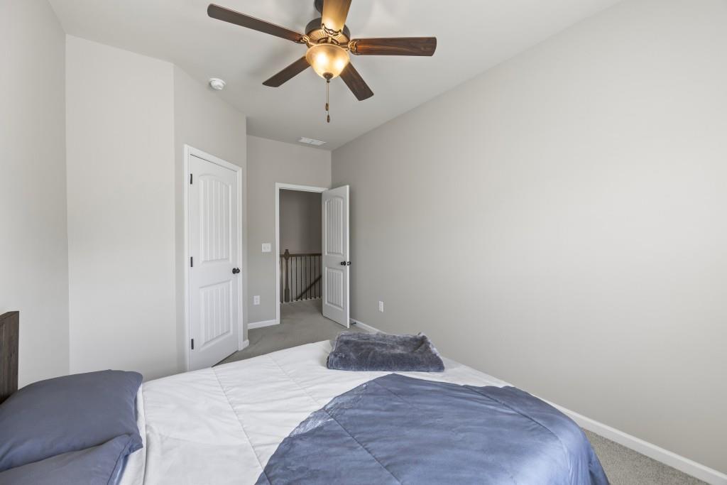 660 Country Ridge Drive Hoschton, GA 30548 - Photo 29 of 58 a bedroom with a bed and a chandelier
