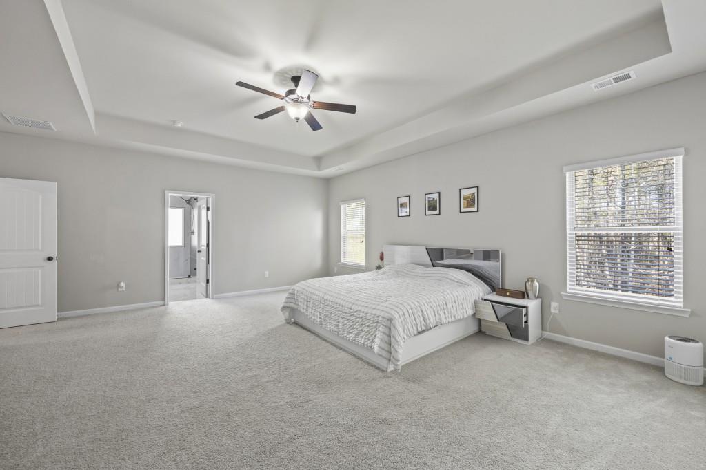 660 Country Ridge Drive Hoschton, GA 30548 - Photo 34 of 58 a spacious bedroom with a bed and a chandelier