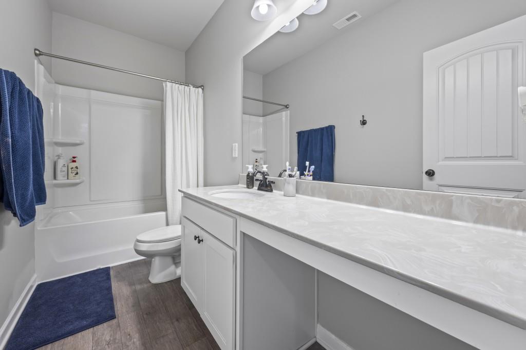 660 Country Ridge Drive Hoschton, GA 30548 - Photo 42 of 58 a bathroom with a sink a toilet a mirror and shower