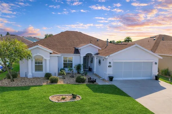 a front view of a house with a garden and plants