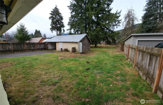 a view of a house with a yard and fence