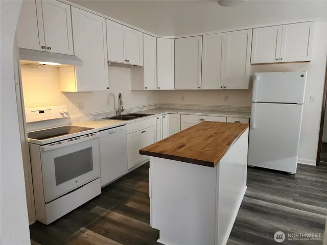 a kitchen with granite countertop white cabinets and white appliances