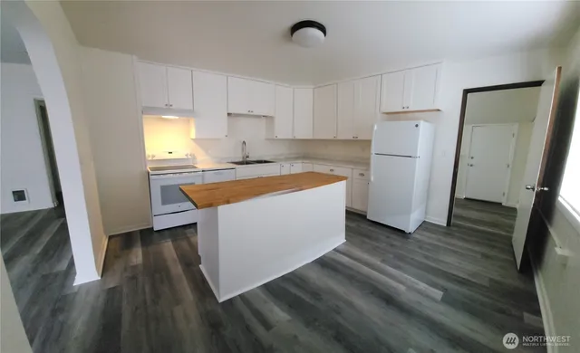 a kitchen with wooden cabinets a sink a refrigerator and a stove