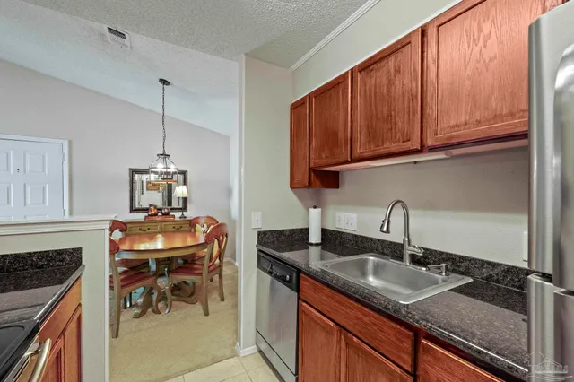 a kitchen with granite countertop a sink a stove and cabinets