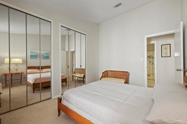 a bedroom with a large bed and a chandelier