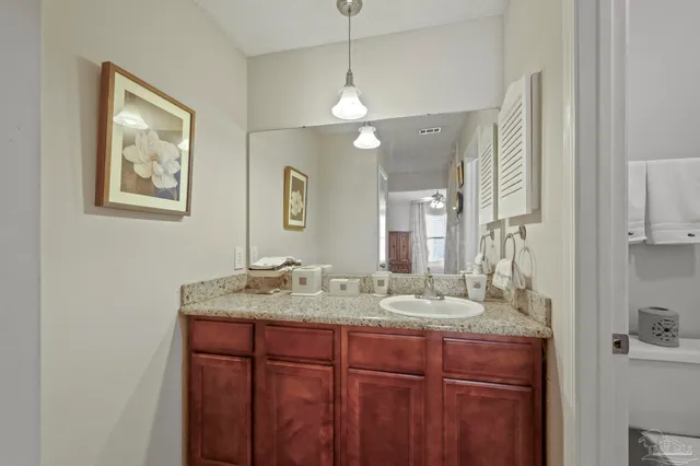 a bathroom with a granite countertop sink a large mirror and shower