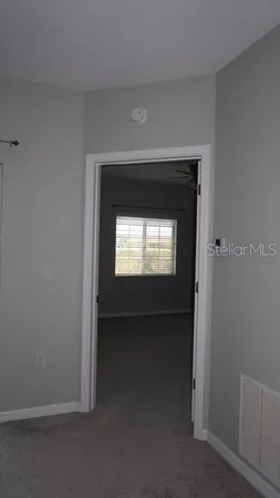 an empty room with a window and a fan