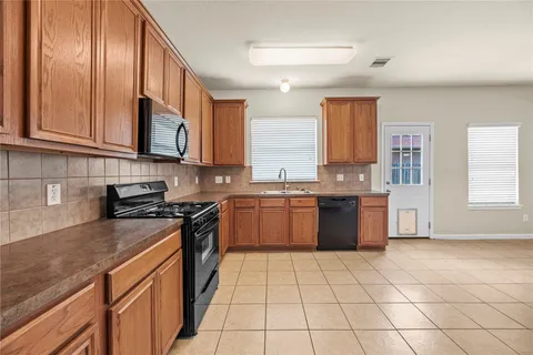 a kitchen with stainless steel appliances granite countertop a stove a sink and a microwave