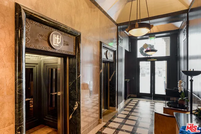 a view of a hallway with wooden floor and windows