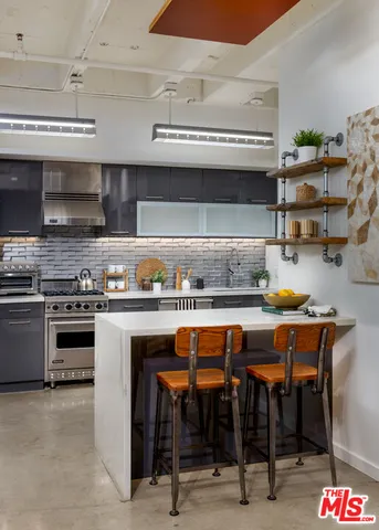 a kitchen with stainless steel appliances granite countertop a stove a sink and a refrigerator