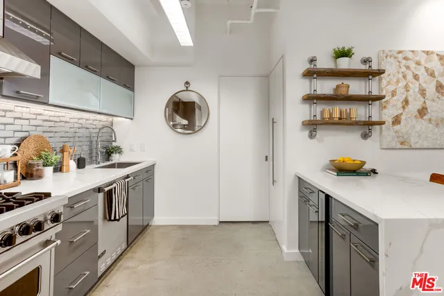 a kitchen with stainless steel appliances a sink a stove and a refrigerator