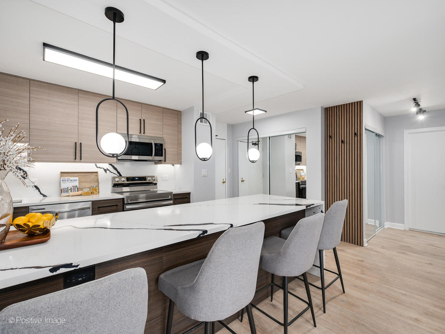 5455 North Sheridan Road, Unit 1511 Chicago, IL 60640 - Photo 7 of 25 a kitchen with stainless steel appliances a dining table chairs and wooden floor