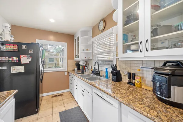 a bedroom with a bed a dresser and a large window