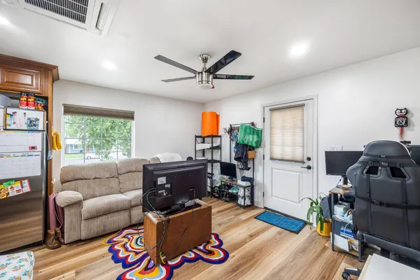 a view of empty room with wooden floor and fan